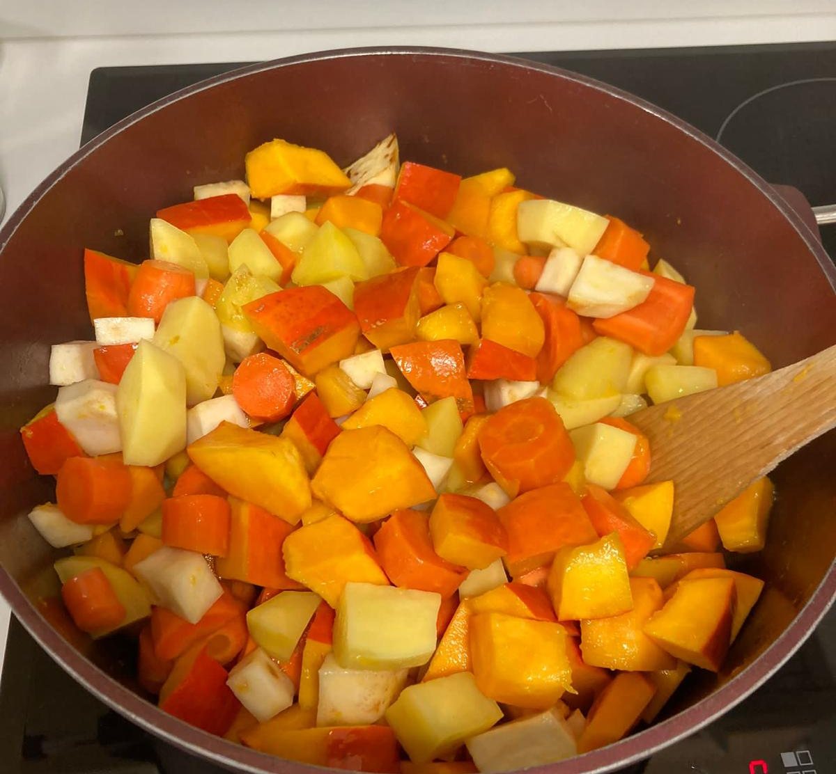 Topf mit frisch geschnittenem Kürbis, Möhren und Kartoffeln