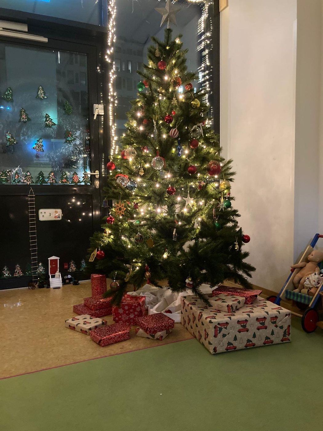 Geschmückter Weihnachtsbaum mit Geschenken in der Kita