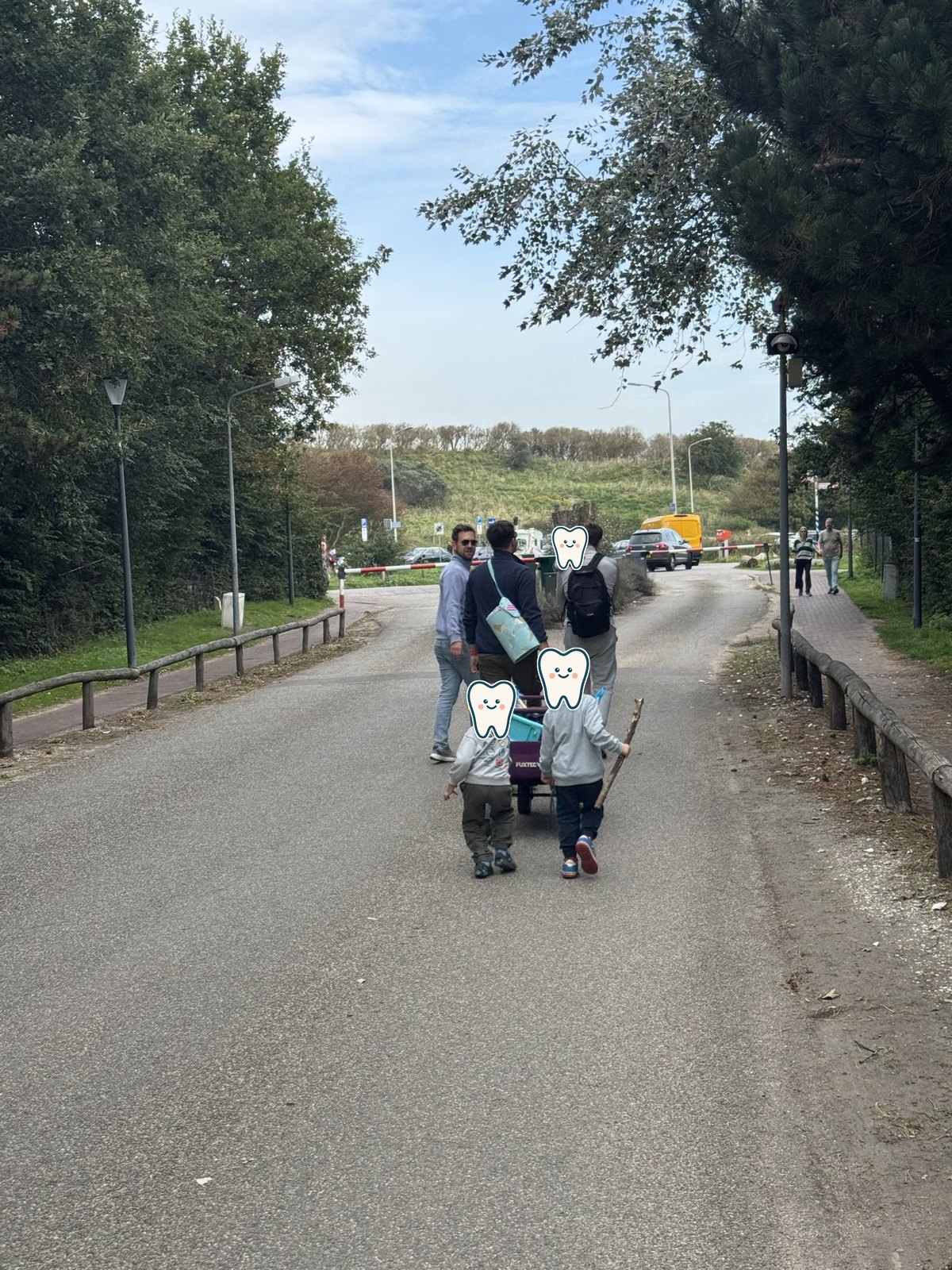 Kinder und Väter ziehen den Bollerwagen Richtung Düne